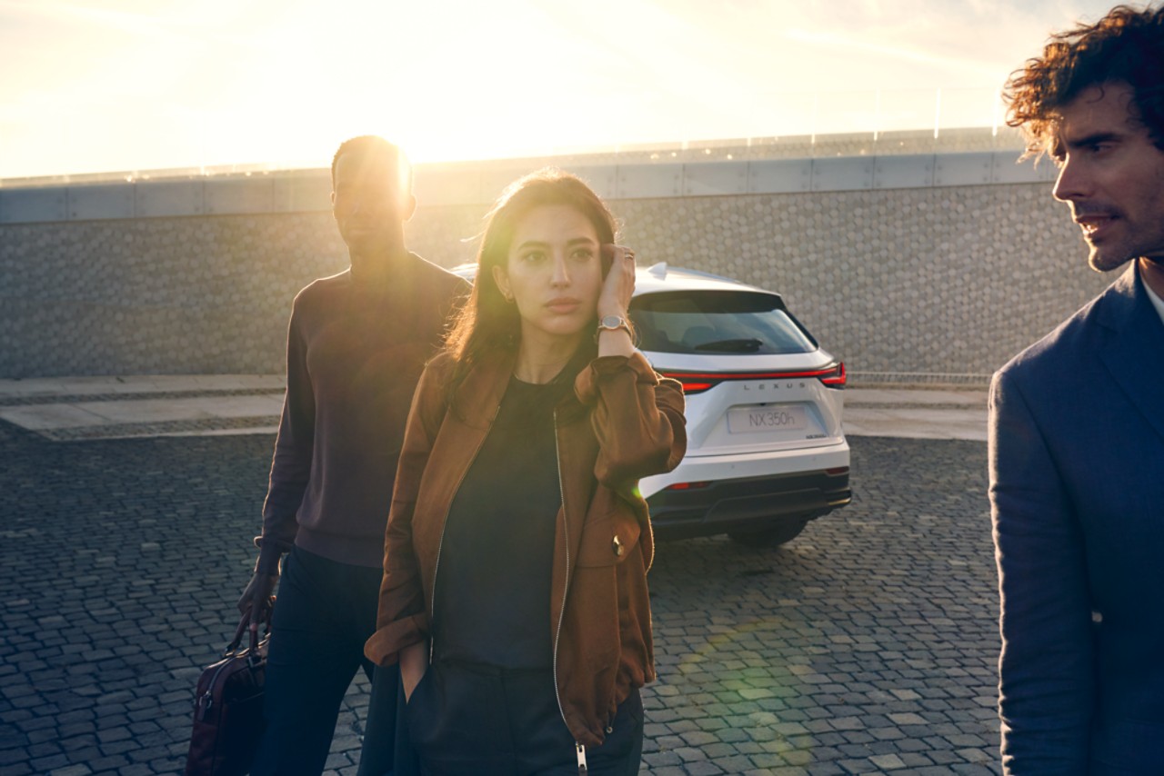 People in front of white Lexus NX