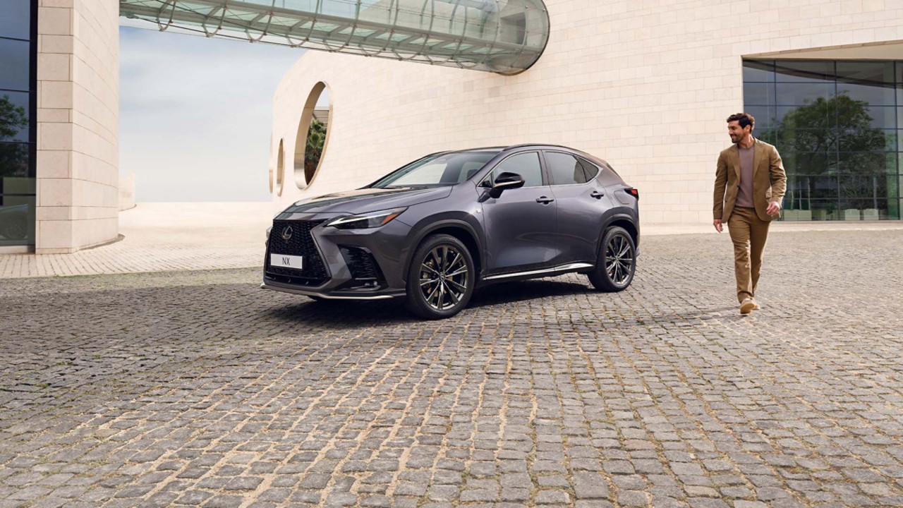 A person walking past a parked Lexus NX