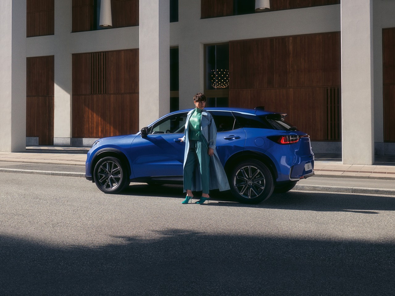 Eine Person steht neben einem Lexus LBX